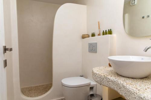 een witte badkamer met een wastafel en een toilet bij Marina's Suites in Naxos Chora