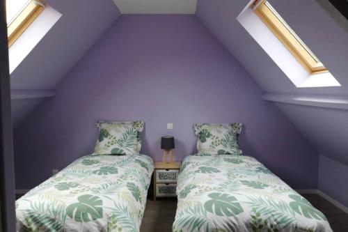 2 Betten in einem Zimmer mit lila Wänden und Fenstern in der Unterkunft Gîte de Brunemont in Diéval