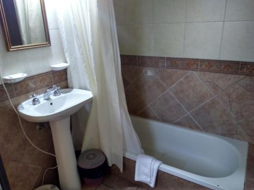 a bathroom with a sink and a tub and a shower at Cabañas La Toscana in Tandil