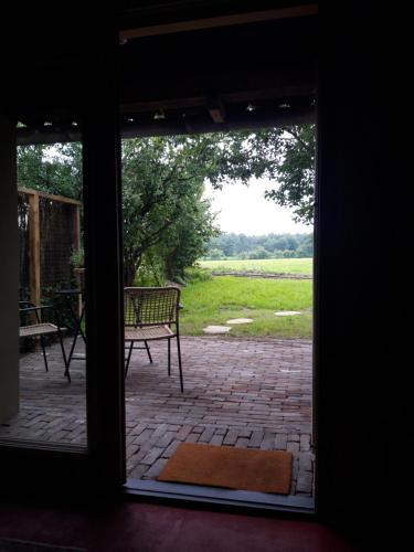 an open door to a patio with a chair outside at 't Buitenverblijf Erve Punte in Losser