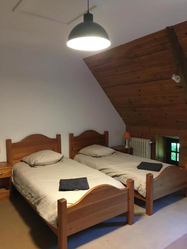 - 2 lits dans une chambre dotée de plafonds en bois dans l'établissement La Tireliere, longère bord de mer avec jardin, à Surville