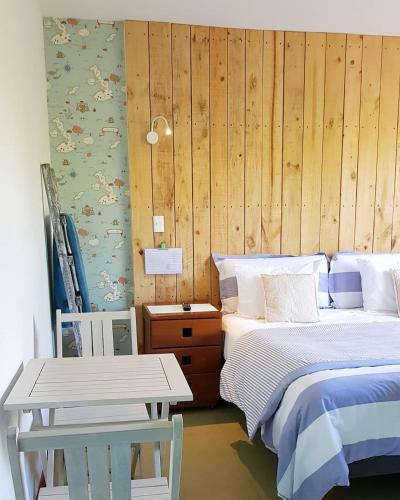 a bedroom with a bed and a wooden wall at Casapapudo Boutique Home in Papudo