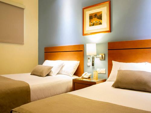 ein Hotelzimmer mit 2 Betten und einem Telefon in der Unterkunft Hotel Abu in Oaxaca de Juárez