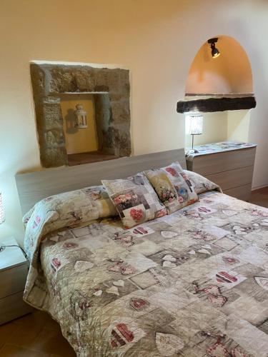 sypialnia z łóżkiem z kołdrą w obiekcie Le Casette nel Borgo w mieście Pitigliano