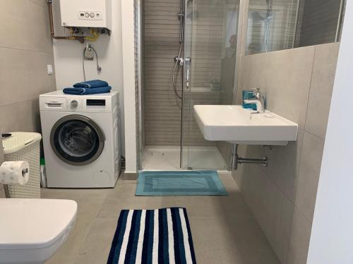 a bathroom with a washing machine and a sink at Apartament Emilia Ustronie Morskie in Ustronie Morskie