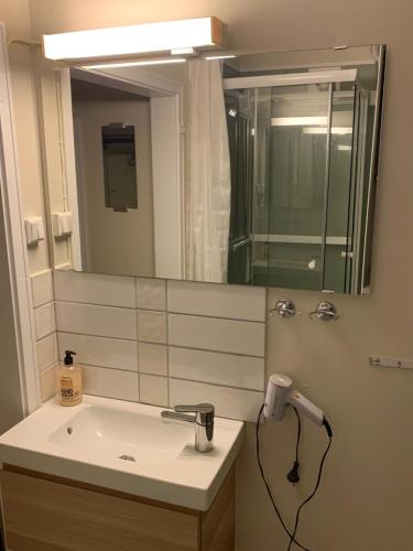 a bathroom with a sink and a mirror at Private house-terrace-garden -parking-WiFi-smartTV in Trondheim