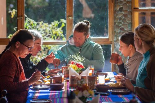 een groep mensen die rond een tafel eten bij Willka T'ika in Urubamba