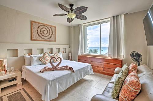 a bedroom with a bed and a couch and a window at Ocean-View Oasis on Playa Norte with Resort Amenities in Isla Mujeres