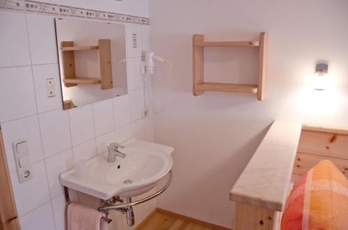 a white bathroom with a sink and a mirror at Kleintödlinggut in Leogang