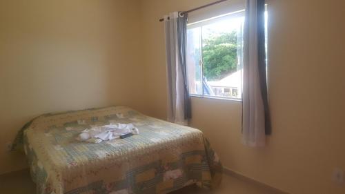 um quarto com uma cama e uma janela em Pousada Viva Mar em Saquarema