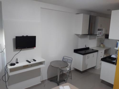 a small kitchen with a table and a stool at Silva Hospedagem in São Luís