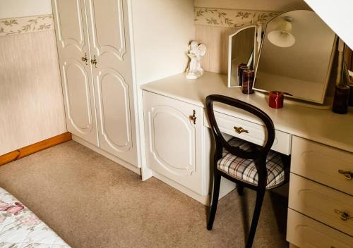 a bedroom with a desk with a chair and a mirror at Moat Holiday Rental in Lisnaskea
