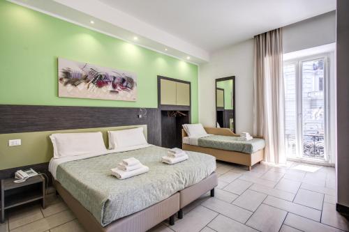 ナポリにあるナポリ スイートの緑の壁のベッドルーム1室(ベッド2台付)