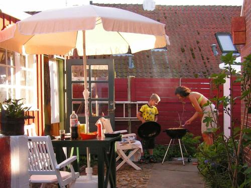 a woman and a child cooking on a grill at 4 person holiday home in Ærøskøbing-By Traum in Ærøskøbing