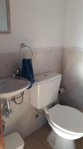 een badkamer met een wit toilet en een wastafel bij Hermosa Casita Paso Patria in Paso de la Patria
