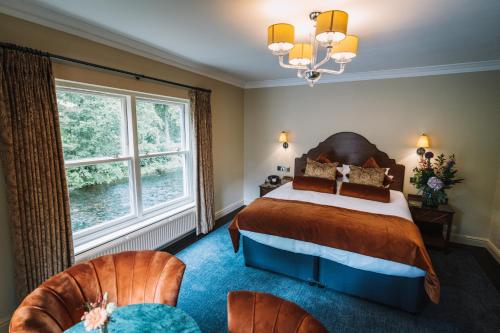 a bedroom with a bed and two chairs at Bridge House Hotel & Silver Howe View Cottage in Grasmere