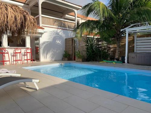 a swimming pool in front of a house at Gite Grenadille Martinique piscine privée, in Sainte-Luce