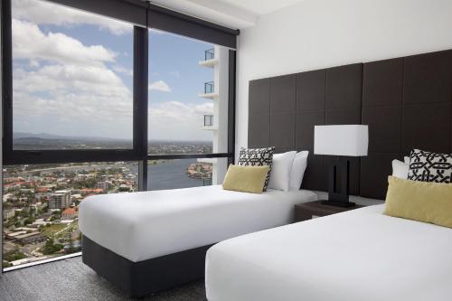 a hotel room with two beds and a large window at Mantra Circle On Cavill in Gold Coast