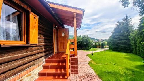 a wooden house with a wooden door and a porch at Sielanówek - Orzechowa Chatka z sauną wanną termalną jacuzzi in Żywiec