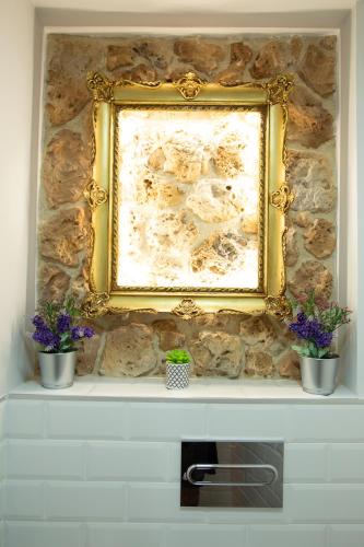 a picture on a stone wall with two potted plants at Vistas de Chamberi in Alhama de Aragón