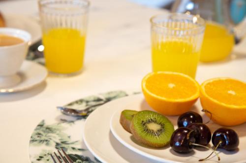 a plate of fruit on a table with orange juice at Vistas de Chamberi in Alhama de Aragón