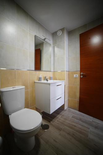 ein Badezimmer mit einem WC, einem Waschbecken und einem Spiegel in der Unterkunft El Rincón de Ceci in Tazacorte
