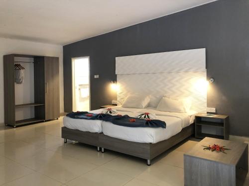 a bedroom with a large bed with a large headboard at Palma Rima Hotel in Kololi