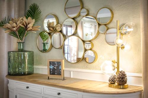 a table with a bunch of mirrors on a wall at Les Pins Blancs en Provence in Le Muy