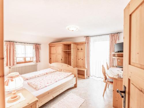 a bedroom with a large bed and a desk at Urlaub am Bauernhof Feldbauer in Landl
