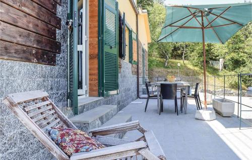 une terrasse avec des chaises, une table et un parasol dans l'établissement 202 - Camera Mansardata tra le Cinque Terre e Portofino - Residence Cherry House, à Carro