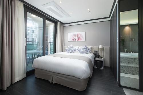 a bedroom with a large bed and a bathroom at Utop Boutique Hotel&Residence in Gwangju