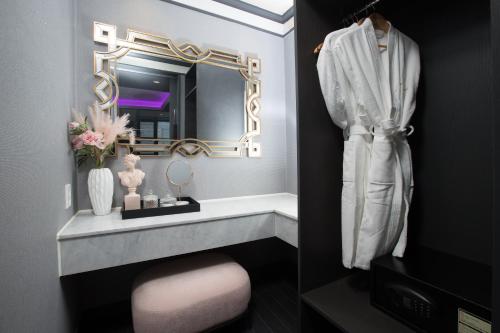 a bathroom with a mirror and a pink stool at Utop Boutique Hotel&Residence in Gwangju