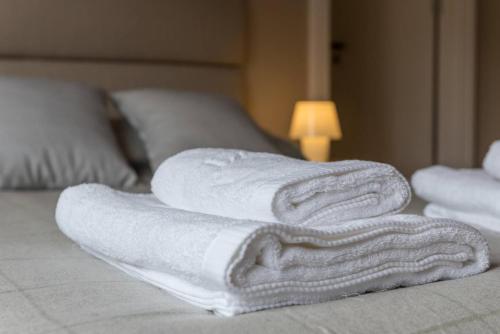 un mucchio di asciugamani seduti sopra un letto di Serenata Boutique Rooms a Porto