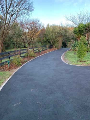 a winding road in a park next to a fence at Weeroona Bed And Breakfast in Rye