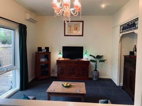 a living room with a television and a table at Weeroona Bed And Breakfast in Rye