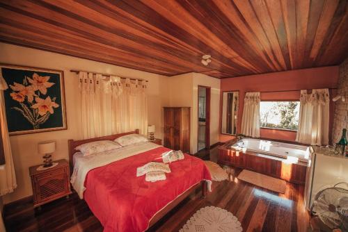 1 dormitorio con cama y bañera. en Sítio Recanto do Araçá, en Visconde De Maua
