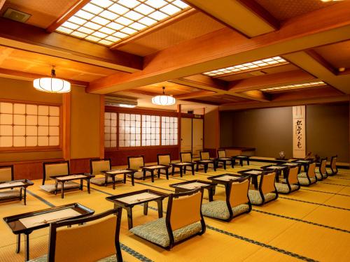 湯河原町にあるWakamatsu HakoneYugawaraのテーブルと椅子と窓のある広い部屋