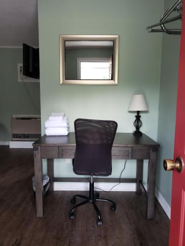 a desk with a chair in a room with a mirror at Blue Ridge Motel in Schroon Lake