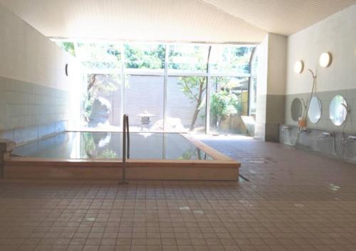 um quarto amplo com uma grande janela e uma banheira em Shiobara Onsen Hotel Ohruri em Nasushiobara