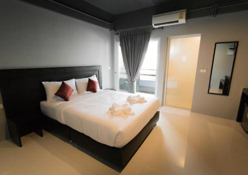 Un dormitorio con una cama grande con dos zapatos. en B-Black Hotel Chonburi, en Chonburi