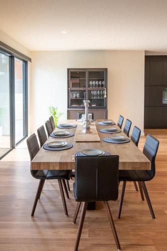 a dining room with a large wooden table and chairs at Johnnies in Robe