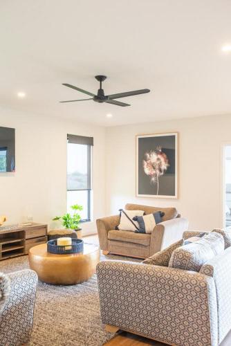 a living room with two couches and a ceiling fan at Johnnies in Robe