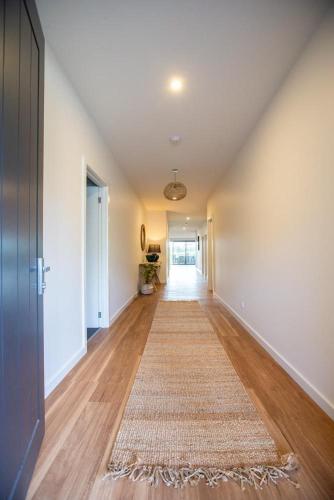 an empty hallway with a rug on a hard wood floor at Johnnies in Robe