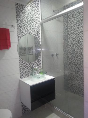 een badkamer met een wastafel en een douche met een spiegel bij Residencial Müller in Canela