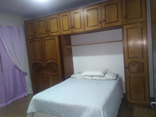 een slaapkamer met een bed en houten kasten bij Residencial Müller in Canela