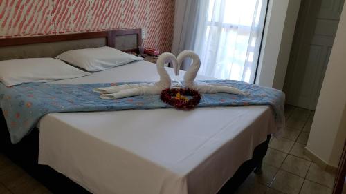 two swans sitting on top of a bed at Pousada Enseada do Corsário in Guarapari