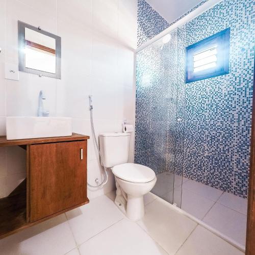 a bathroom with a toilet and a glass shower at Chalés Pulo do Gato in Canoa Quebrada