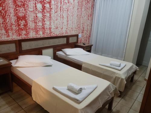 two beds in a hotel room with towels on them at Pousada Enseada do Corsário in Guarapari