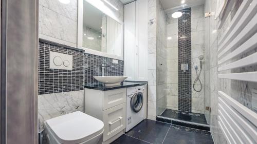 een badkamer met een wasmachine en een wastafel bij Willa na Wydmach in Jurata