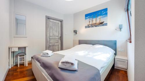 Un dormitorio con una cama con toallas. en Willa na Wydmach, en Jurata
